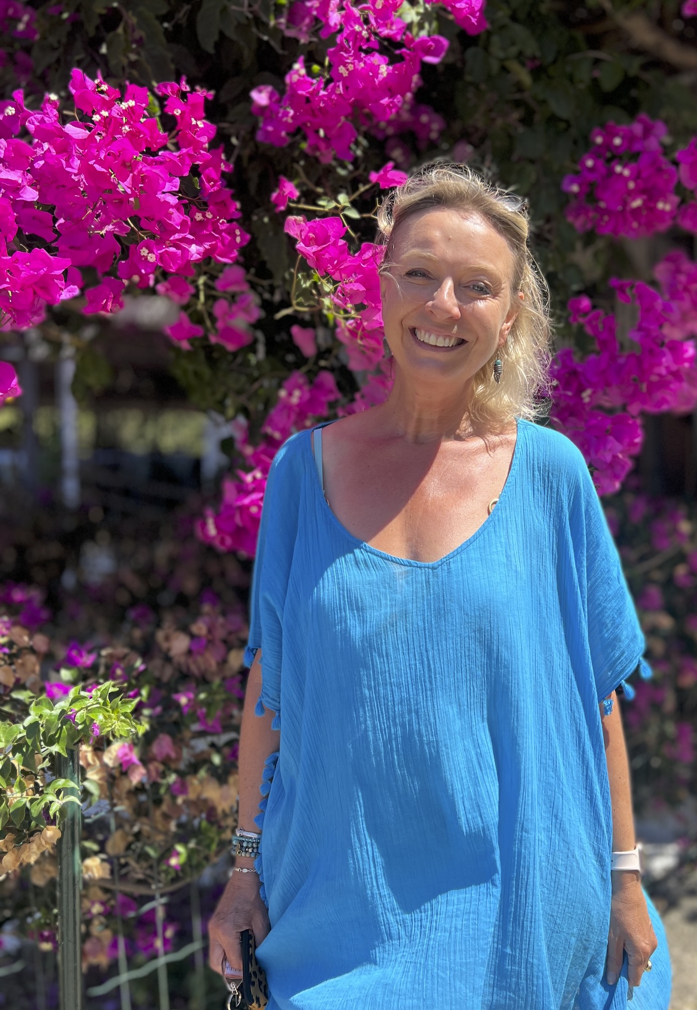 Margot Raggett MBE, owner of Korianna House, in front of bougainvillea in Kefalonia